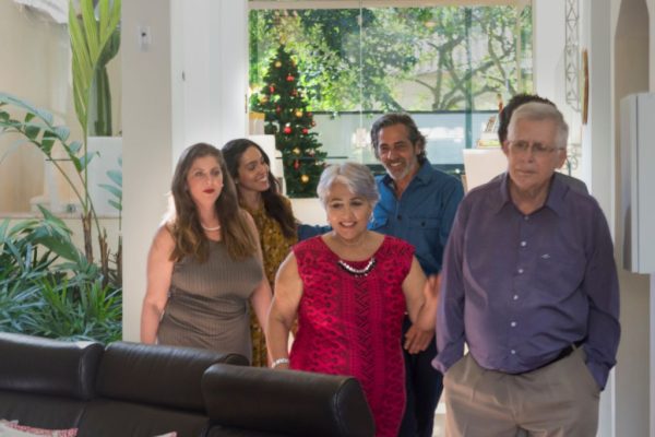Família chegando em casa decorada para o Natal, simbolizando segurança e tranquilidade proporcionadas pela portaria remota Stratum.